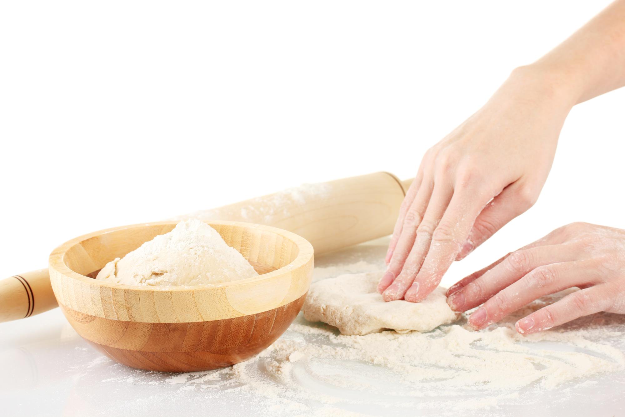 Hands kneading dough in workshop